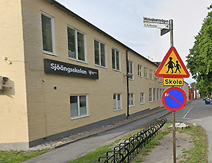 Sjöängsskolan exteriör med skylt för skolområde och ingen parkering i Askersund, Sverige, visande säkerhetsåtgärder för barn.